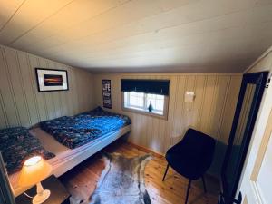 a small bedroom with a bed and a window at Atmospheric cabin by Lesjaskogsvatnet in Lesja