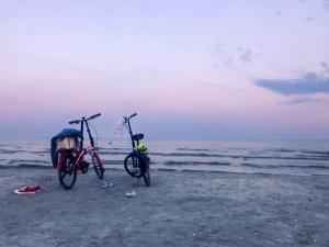 two bikes parked on a sandy beach near the ocean at Porto Franco Sulina in Sulina