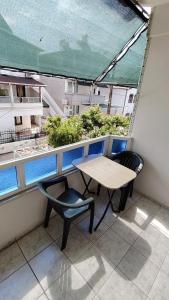 a balcony with a table and a chair and a window at Avsa BARAN MOTEL apart in Marmara