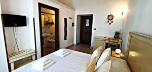 a bedroom with a bed and a television and a bathroom at Casina Raho B&B in Nardò