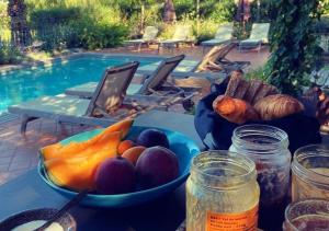 a table with a bowl of fruit and a bowl of vegetables at Clos Des Aspres in Ortaffa