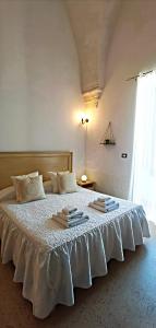 a bedroom with a white bed with towels on it at Casina Raho B&B in Nardò