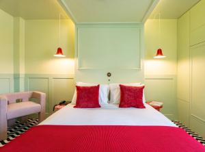 a bedroom with a large bed with red pillows at &Tales Hotel - Óbidos in Óbidos