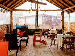 a restaurant with tables and chairs and a fireplace at CABAÑAS SANTA TERESA in Tibasosa