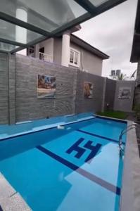 a swimming pool with blue water in front of a house at Homelands in Port Harcourt