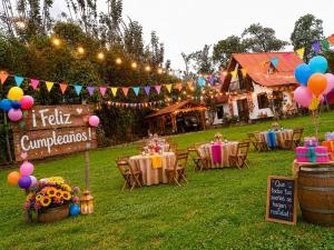 an outdoor party with tables and balloons and a sign at CABAÑAS SANTA TERESA in Tibasosa +24 photos