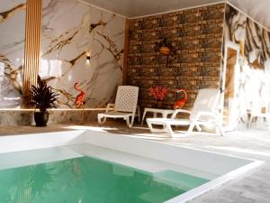 a room with a pool and chairs and a brick wall at CABAÑAS SANTA TERESA in Tibasosa