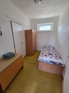 a small bedroom with a bed and a window at SALEM apartmany in Radava +14 photos