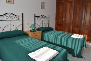 a bedroom with two beds with green sheets and a lamp at Céntrico Apartamento Rosalía 3H in O Grove