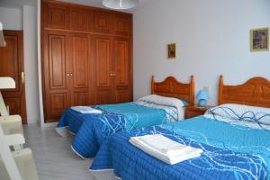 a bedroom with two beds with blue comforters at Céntrico Apartamento Rosalía 3H in O Grove