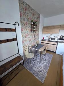 a small kitchen with a table and chairs in a room at SALEM apartmany in Radava