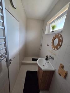 a small bathroom with a sink and a window at SALEM apartmany in Radava