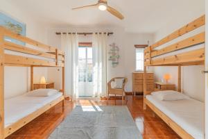 two bunk beds in a room with wooden floors at Baleal Happiness Surf House in Baleal +18 photos