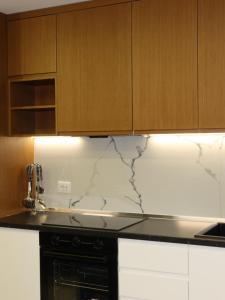a kitchen with white marble counter top and wooden cabinets at Marbel Sea View in Shëngjin +37 photos