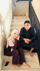 a man and a woman sitting on the stairs at Hotel in Panenjoan