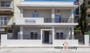 a white building with a nice and cozy sign on it at Nice and Cozy Apartments in Néa Khilí