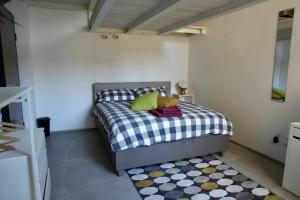 a bedroom with a bed with a checkered blanket and a rug at Guglie's Guest House in Livorno