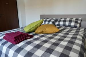 a bed with a blue and white checkered blanket and pillows at Guglie's Guest House in Livorno