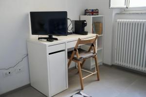 a computer desk with a tv and a chair at Guglie's Guest House in Livorno