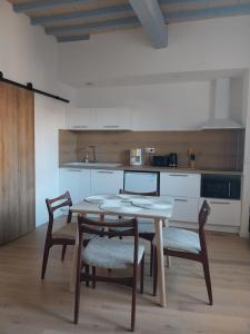 a kitchen with a table and chairs in a room at L'appartement de Sigrid in Pézenas