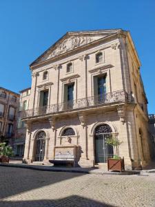 an old stone building with a balcony on a street at L'appartement de Sigrid in Pézenas