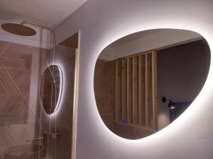 a bathroom with a large circular mirror on the wall at L'appartement de Sigrid in Pézenas +37 photos