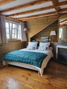 a bedroom with a large bed in a wooden room at Maison d'Hôtes L'Intemporelle in Bagnères-de-Bigorre