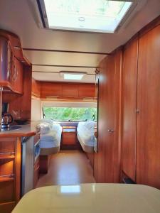 a small room with two beds and a kitchen at The Sûre & Simple Caravan in Houschthauser