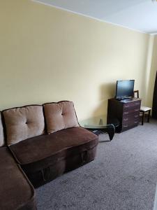 a living room with a couch and a tv at SunKiss in Melnragė +1 photo