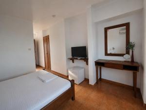a bedroom with a bed and a desk and a mirror at Tortuga in Costinesti