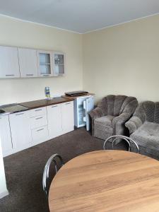 a living room with a table and two chairs and a kitchen at SunKiss in Melnragė