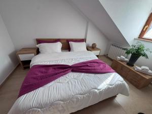 a bedroom with a large bed with a purple blanket at Jeton Resort in Çerenec i Poshtëm