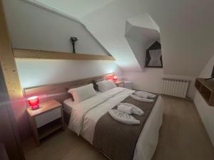 a bedroom with a bed with two towels on it at Jeton Resort in Çerenec i Poshtëm