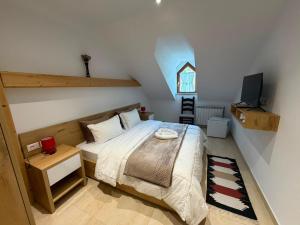 a small bedroom with a bed and a tv at Jeton Resort in Çerenec i Poshtëm +15 photos