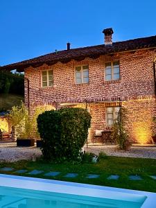 a brick house with a pool in front of it at MiaClara Relais in Alba