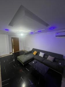 a living room with a black couch and purple ceilings at Sweet home in Ariana