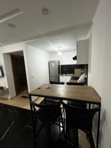 a kitchen with a wooden table and black chairs at Sweet home in Ariana