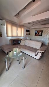 a living room with a large couch and a table at revisapartments brown in Neos Marmaras +11 photos