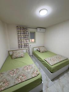 a bedroom with two beds and a window at Studio 3rd Floor Blumar one bedroom in El Alamein