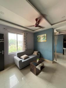 a living room with a couch and a table at Pure Bliss 3BHK Stay in Guwahati