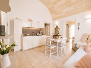 a kitchen and living room with a table and chairs at Dimora IL TULIPANO BIANCO in Massafra