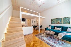 a living room with a blue couch and a table at Gem Stone City Center in Olomouc