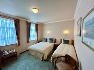a hotel room with two beds and a chair at Rathbaun Hotel in Lisdoonvarna +75 photos