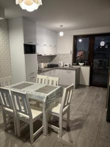 a kitchen with a table and chairs in a kitchen at Tęczowe Lato in Sarbinowo