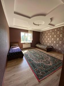 a large room with two beds and a rug at Panorama in Karakol