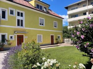 a yellow house with a yard with flowers at Geidorf Residenz - Serviced Apartments & Parking in Graz
