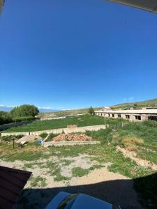 a view of a field with a building in the background at Panorama in Karakol