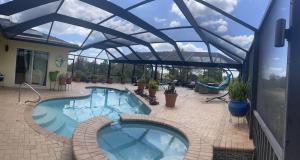 a large swimming pool with a glass roof at Serenity Garden Studio with Pool in Naples