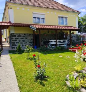 a house with a yard with red flowers at Kuća Despot in Kremna