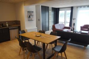 a living room with a wooden table and chairs at Ty Le Gall in Plouescat